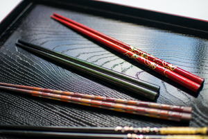Beautiful chopsticks in red, black, brown on the lacquer plate